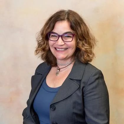 a woman wearing glasses and a suit