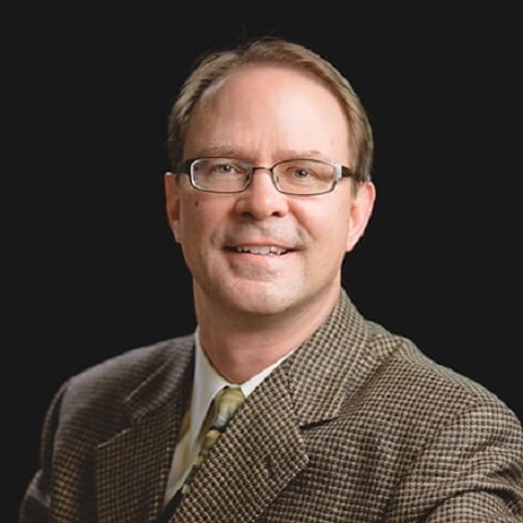 a man wearing glasses and a suit