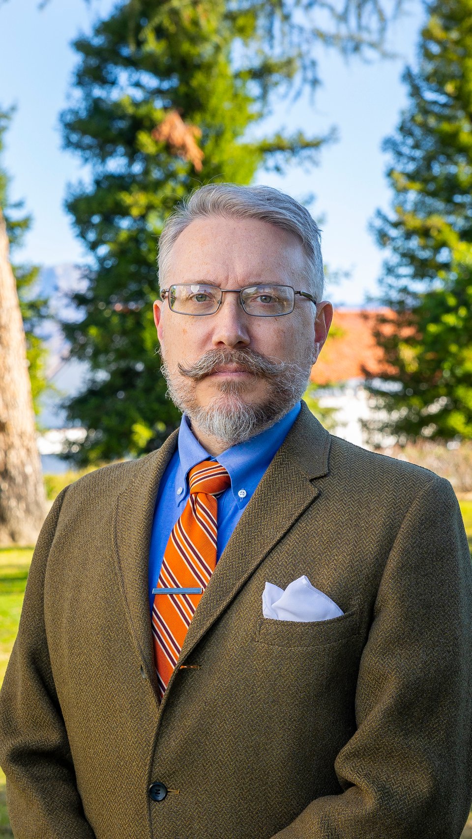 a man with a mustache and beard wearing a suit and tie