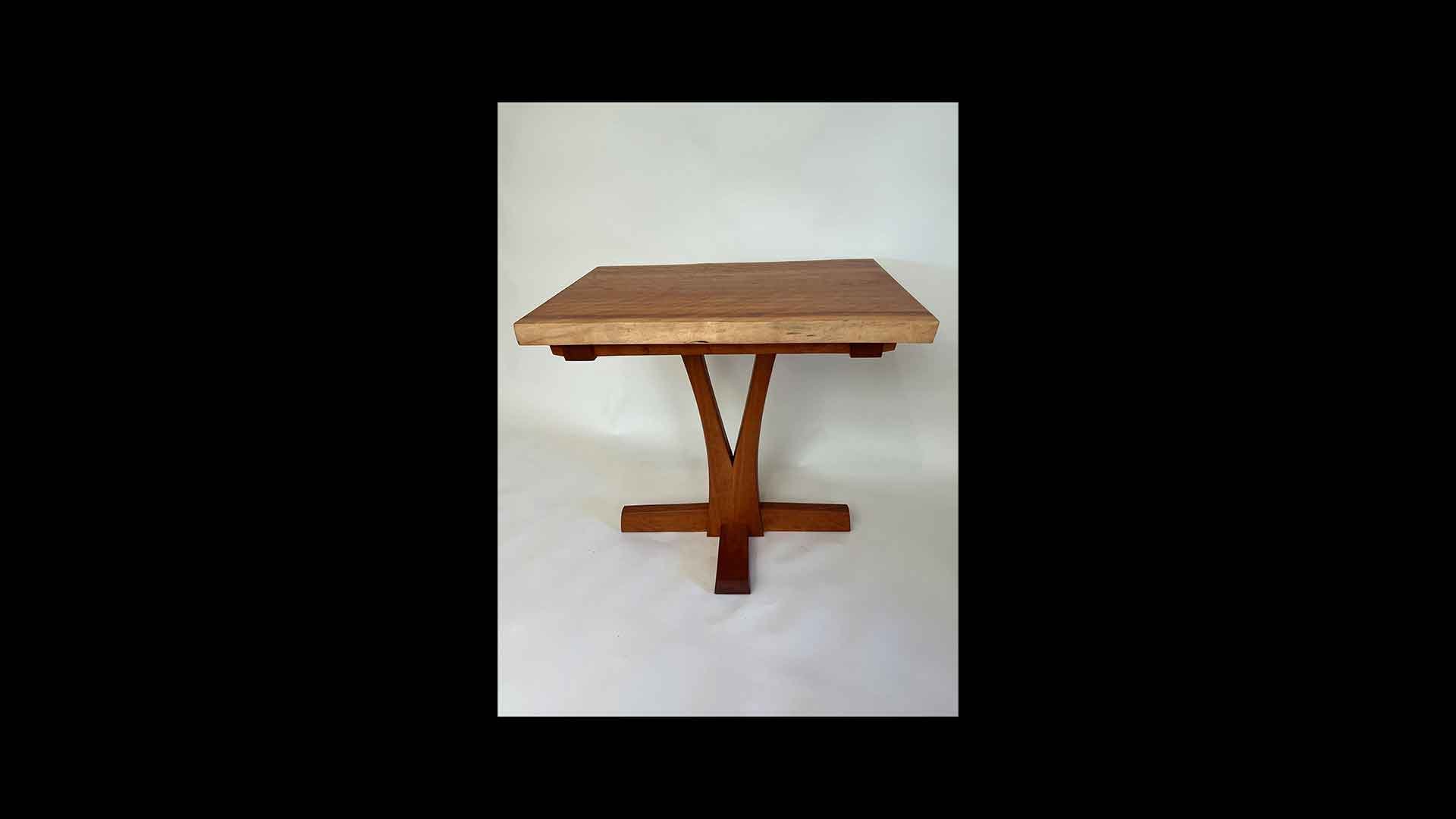 a wooden table with a cross leg