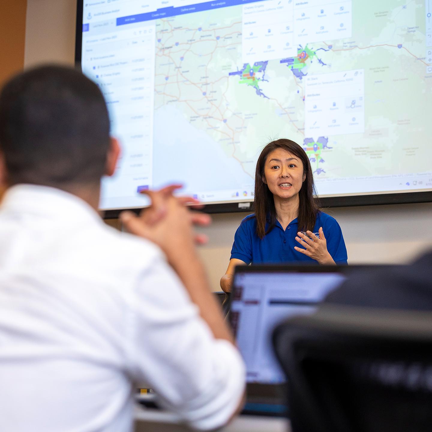 a woman in front of a large screen