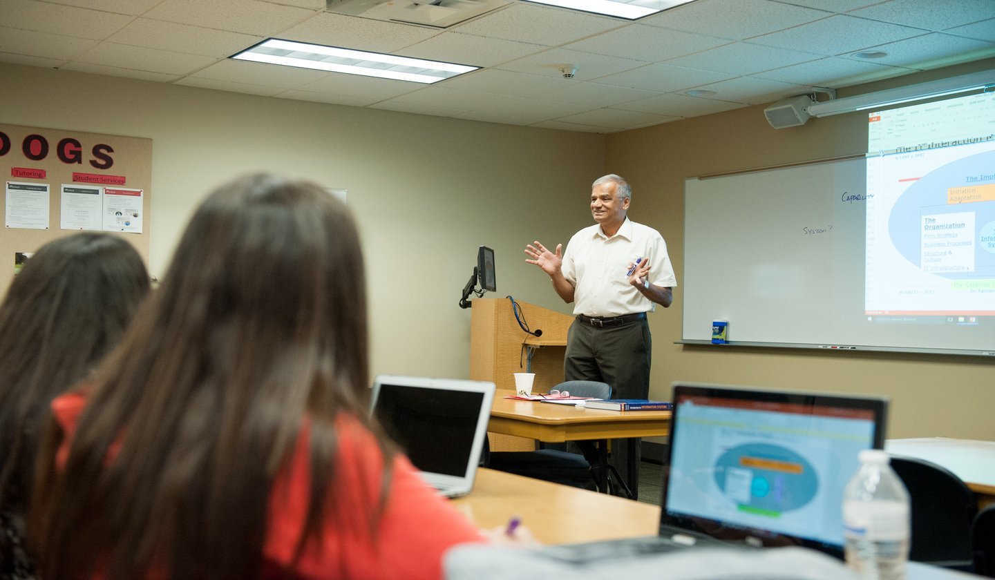 a man standing in front of a table with a woman in the background