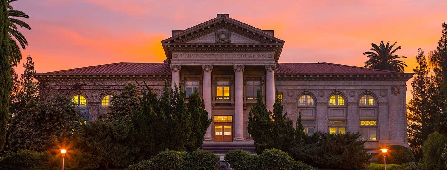 a building with columns and a pink sky