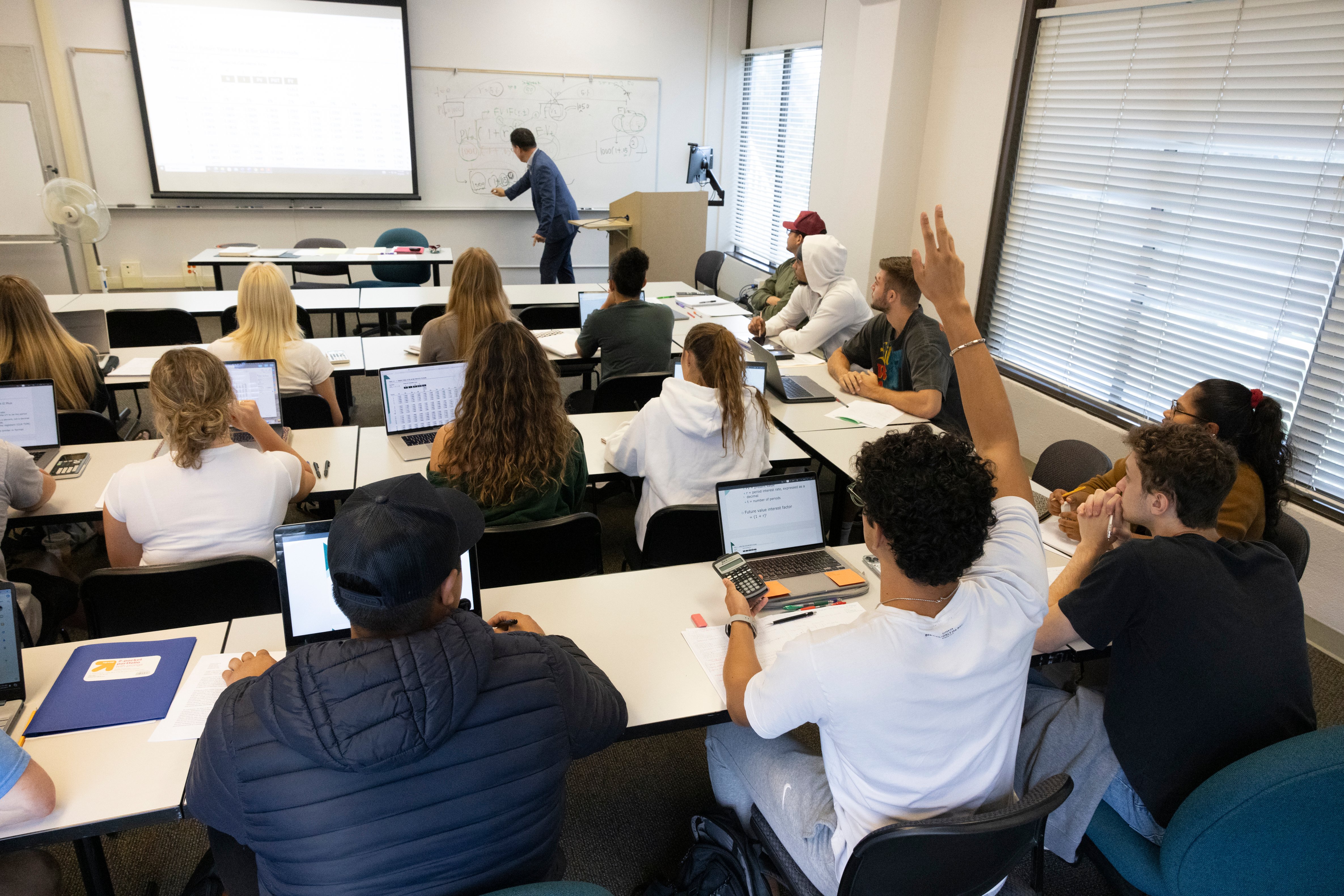 a man standing in front of a classroom with a group of people