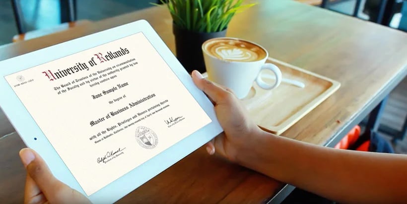 a hand holding a tablet with a cup of coffee and a plant