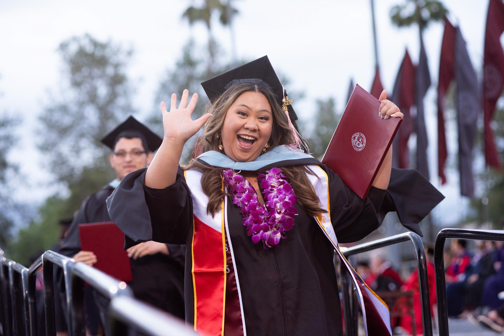 a woman in a graduation gown holding a diploma