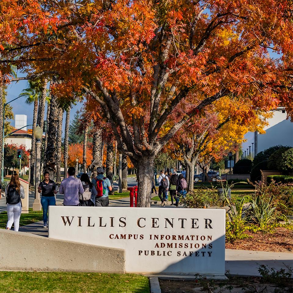 a group of people walking under a sign