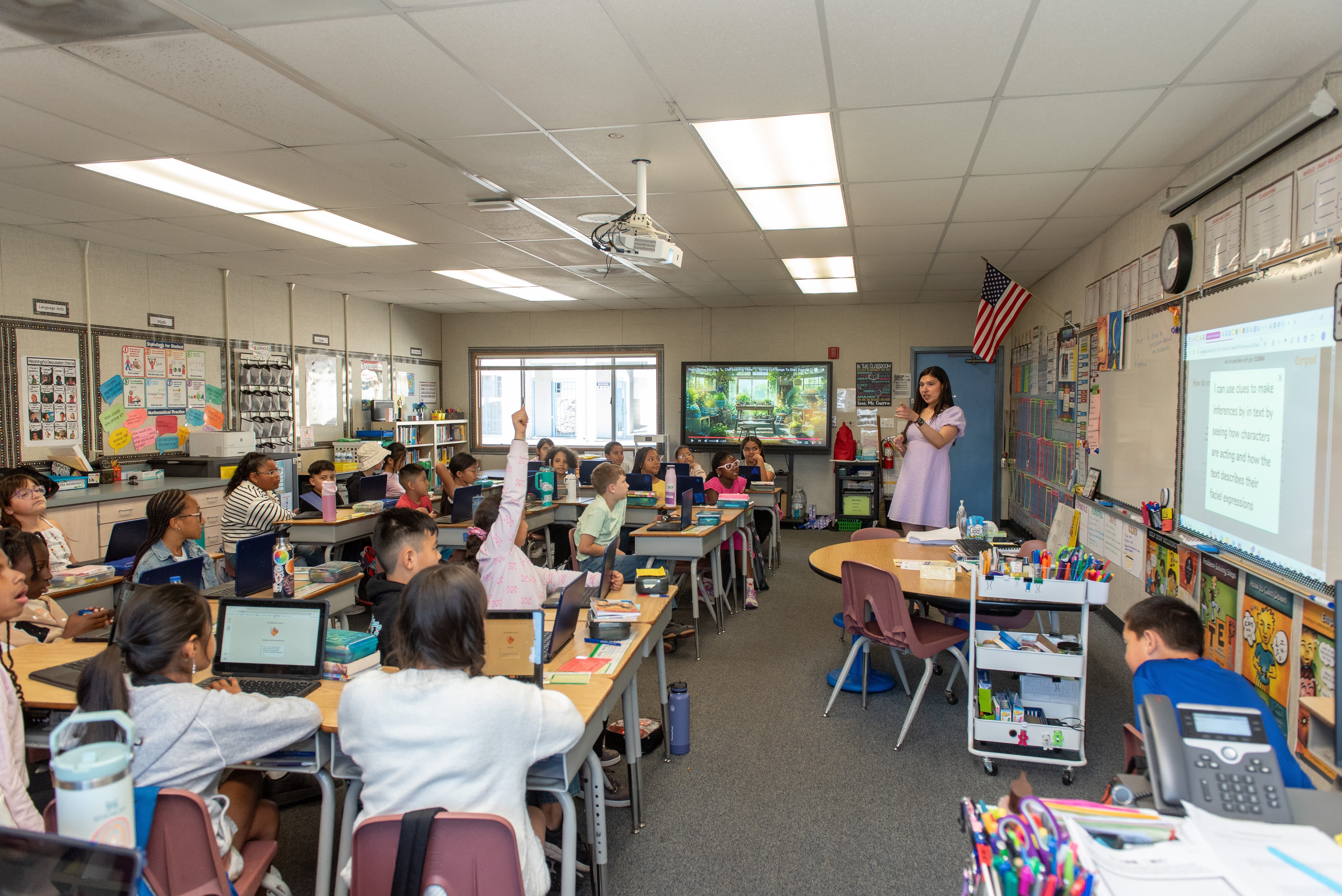 a woman standing in front of a group of students in a classroom