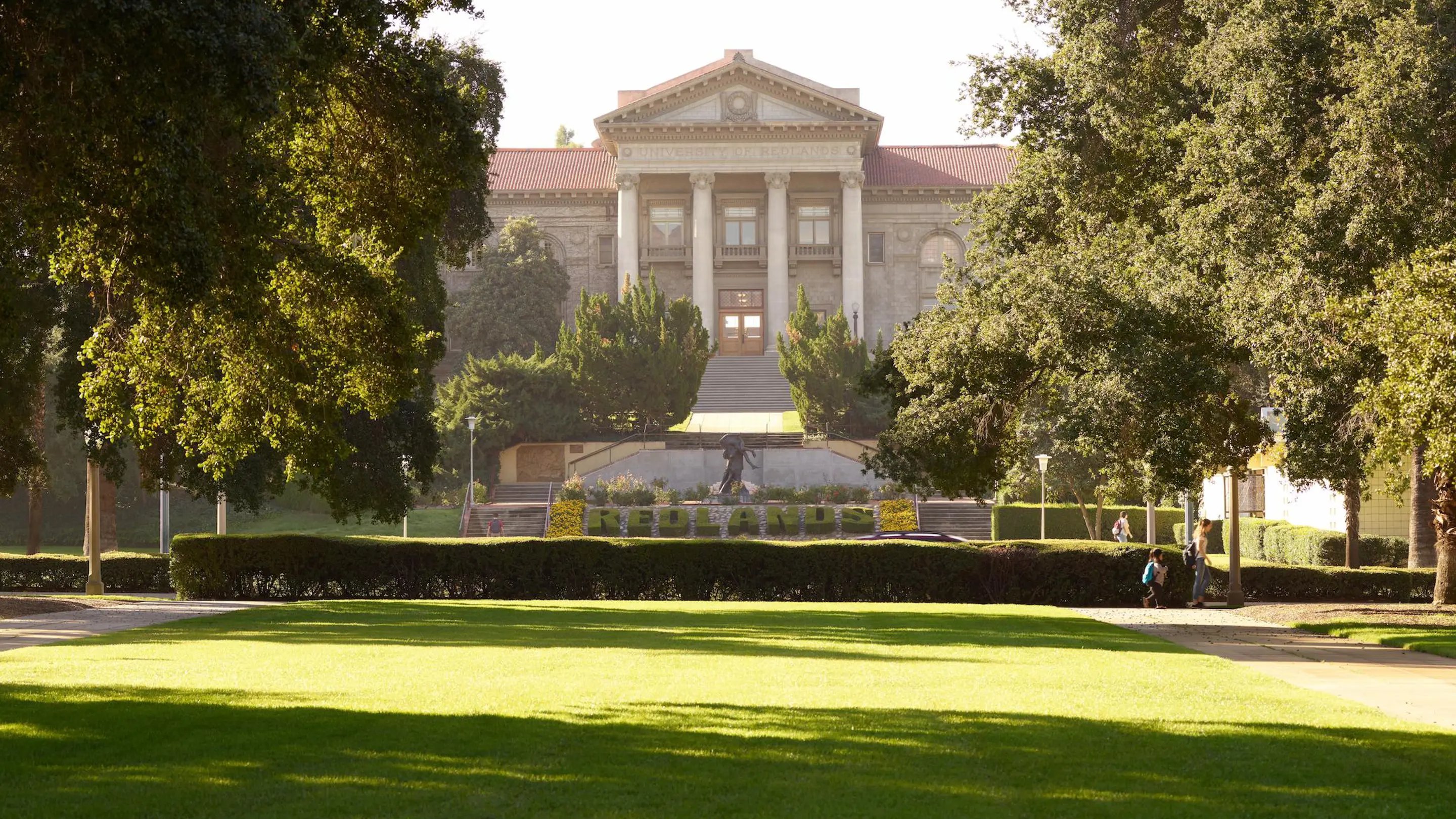 a large building with a lawn and trees