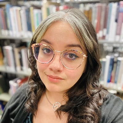 a woman wearing glasses in a library