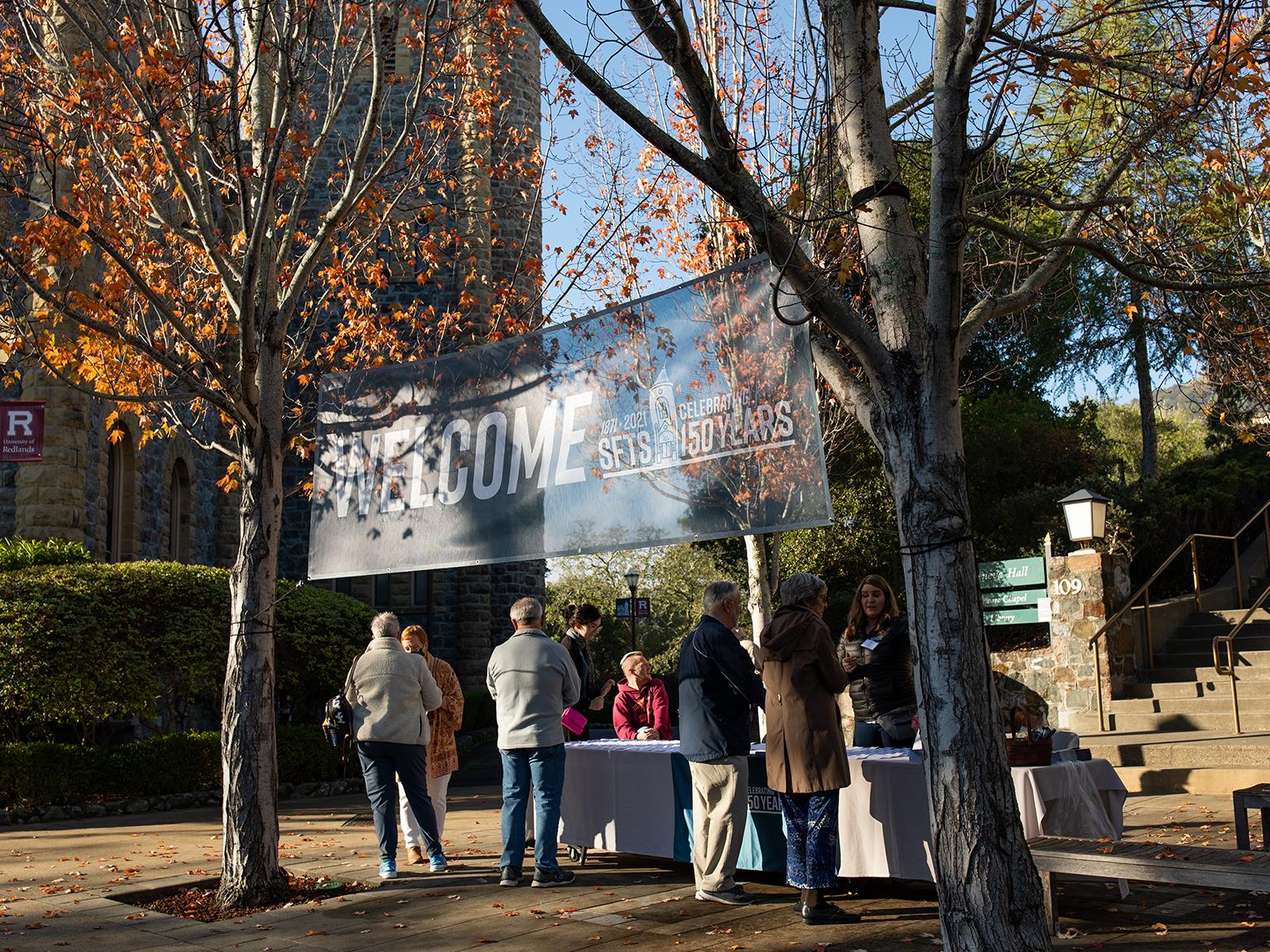 a group of people standing under a sign