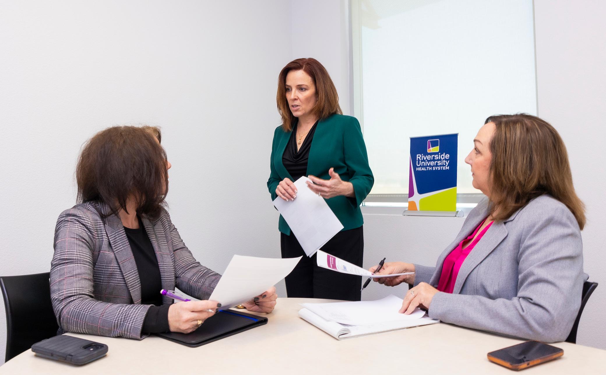 a woman standing in front of a group of women