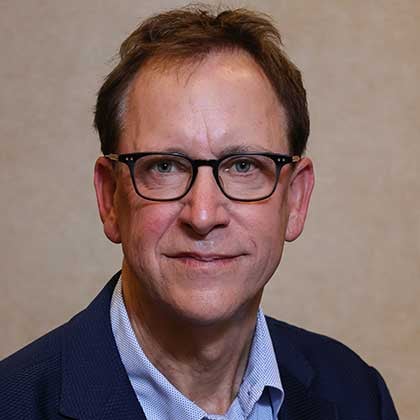 Rob Harris sitting and smiling for photo.