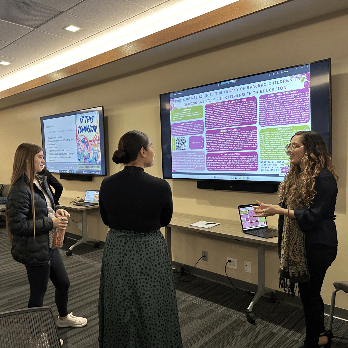 a group of women standing in front of a large screen