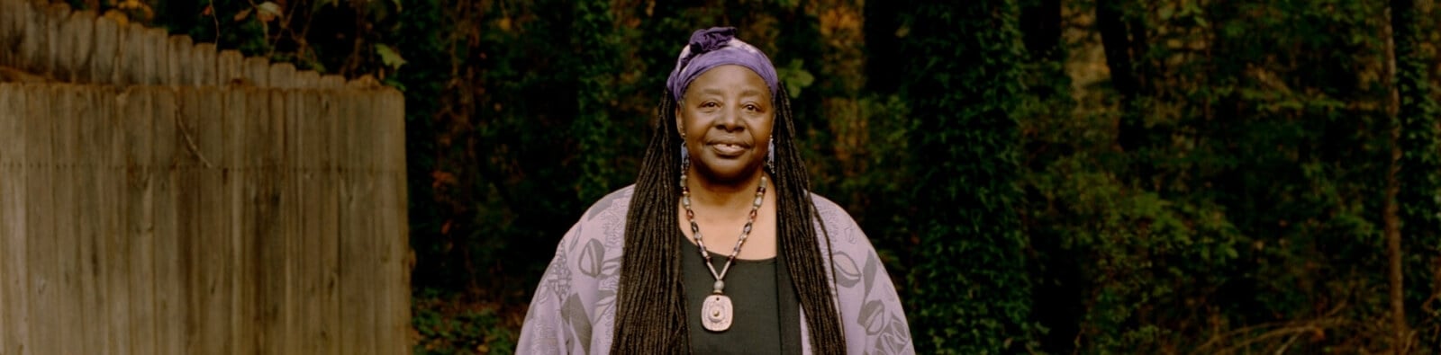 a woman with long hair and a purple head wrap