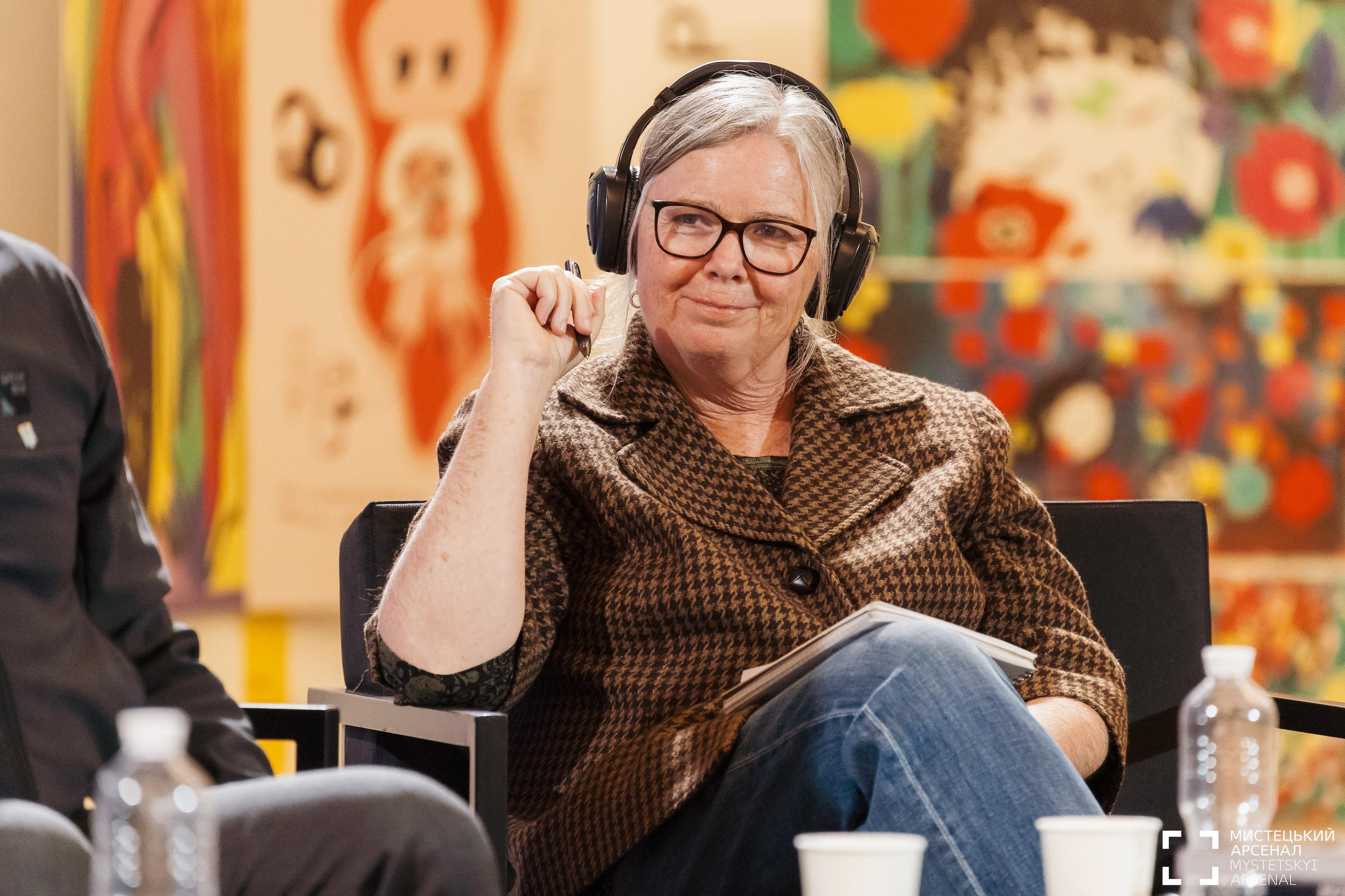 a woman wearing headphones and sitting in a chair