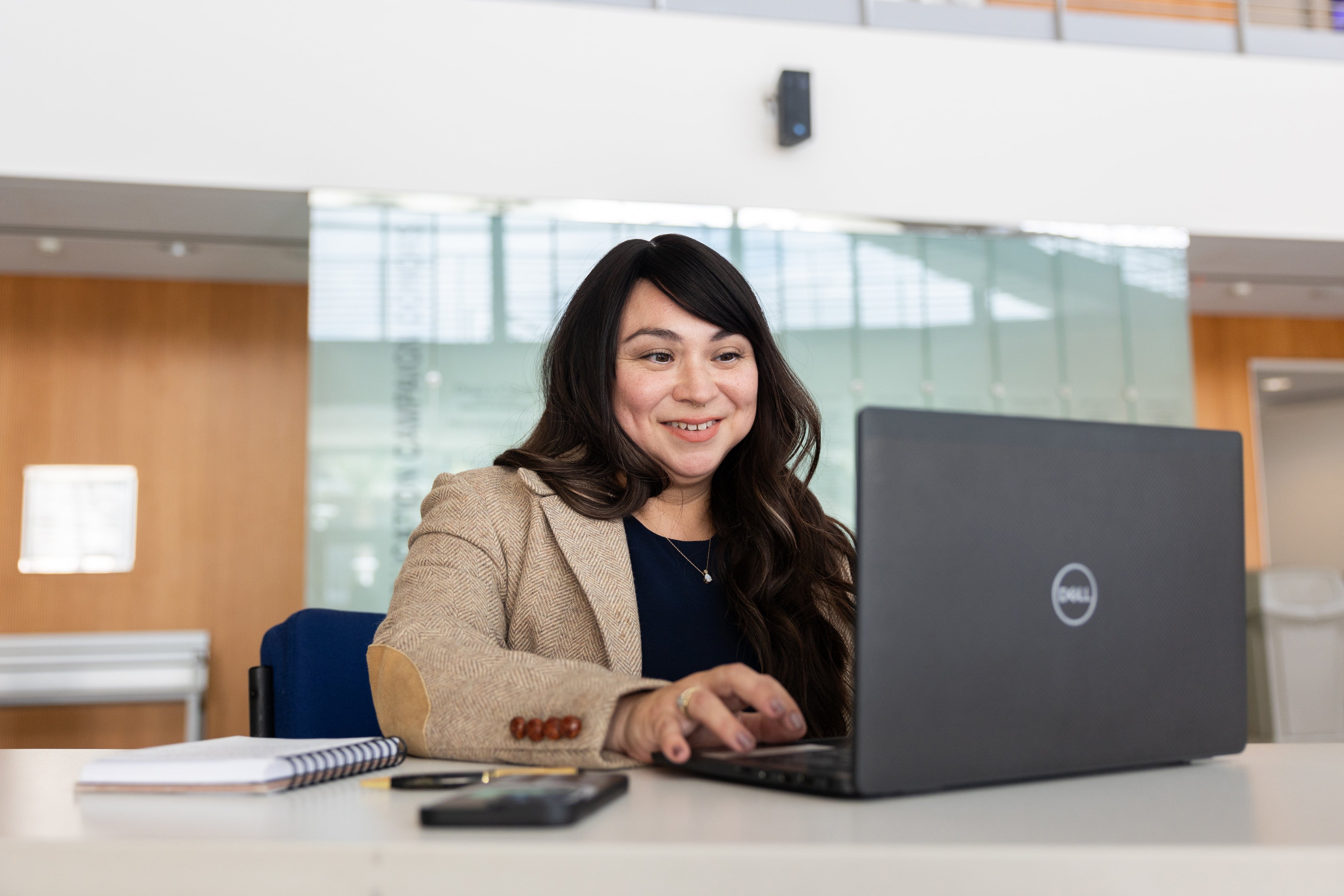 a woman sitting at a desk with a laptop