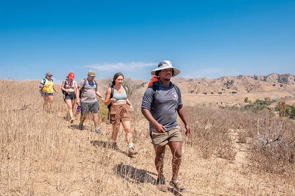 a group of people hiking in a dry field