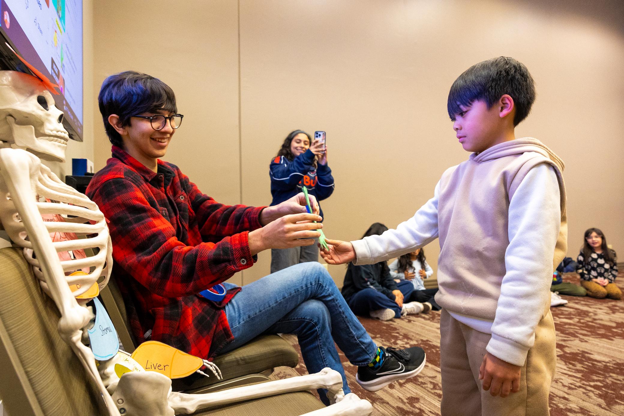 a boy giving a toothbrush to a boy