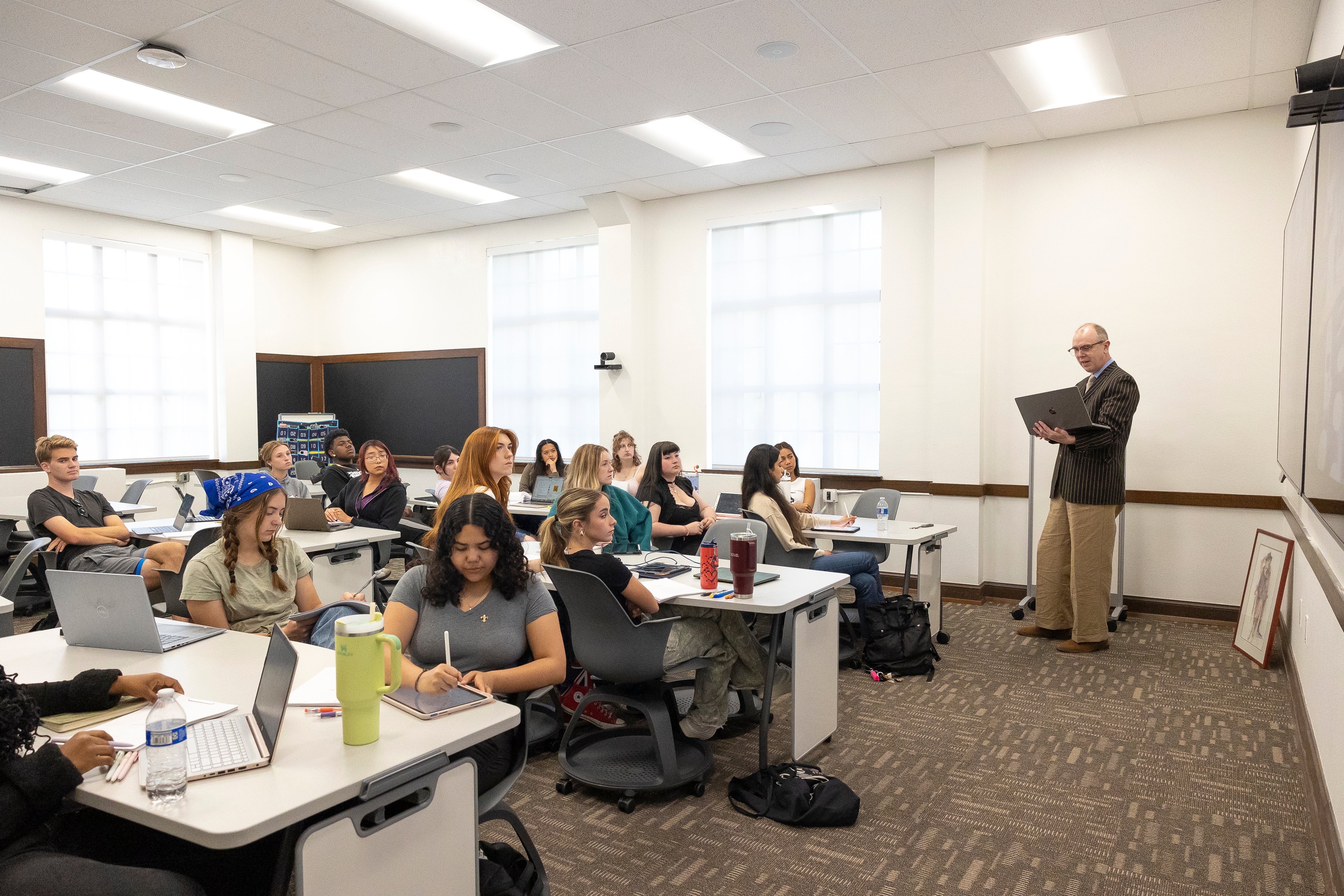 a man standing in front of a group of people in a classroom