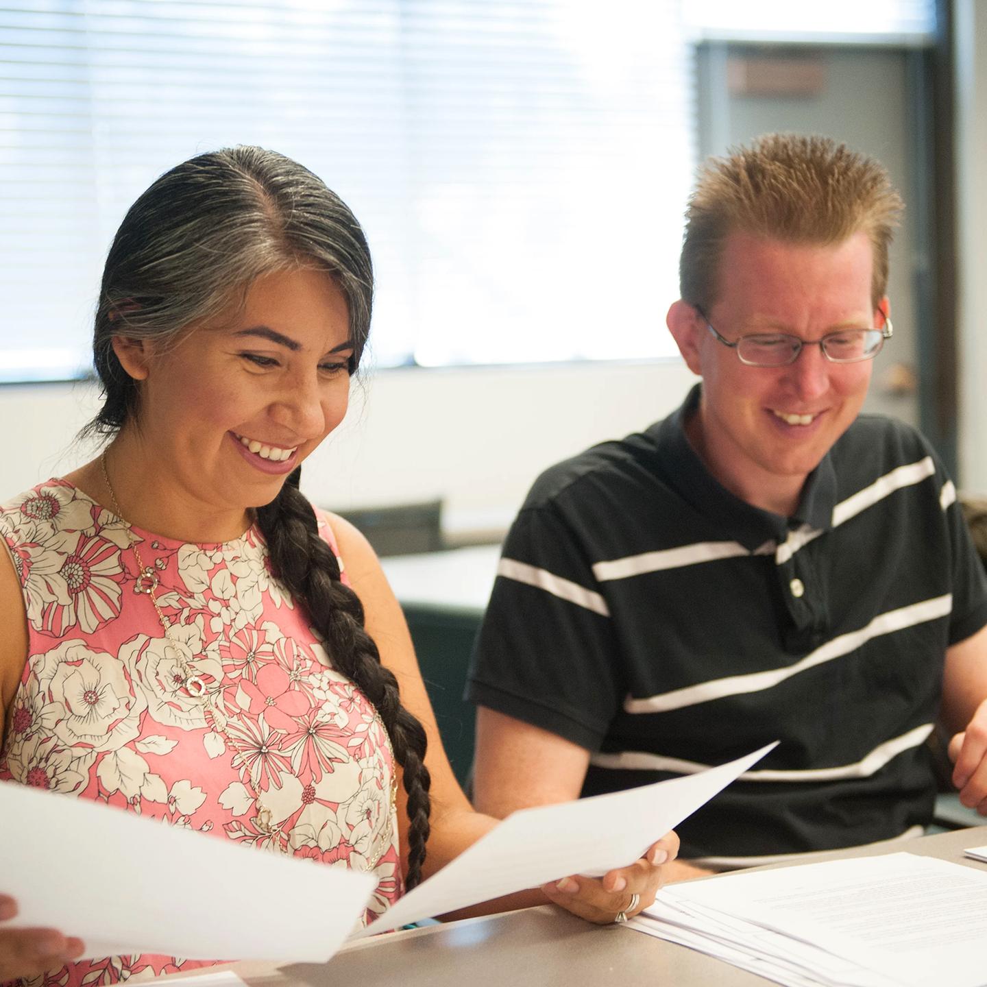 a man and woman looking at papers