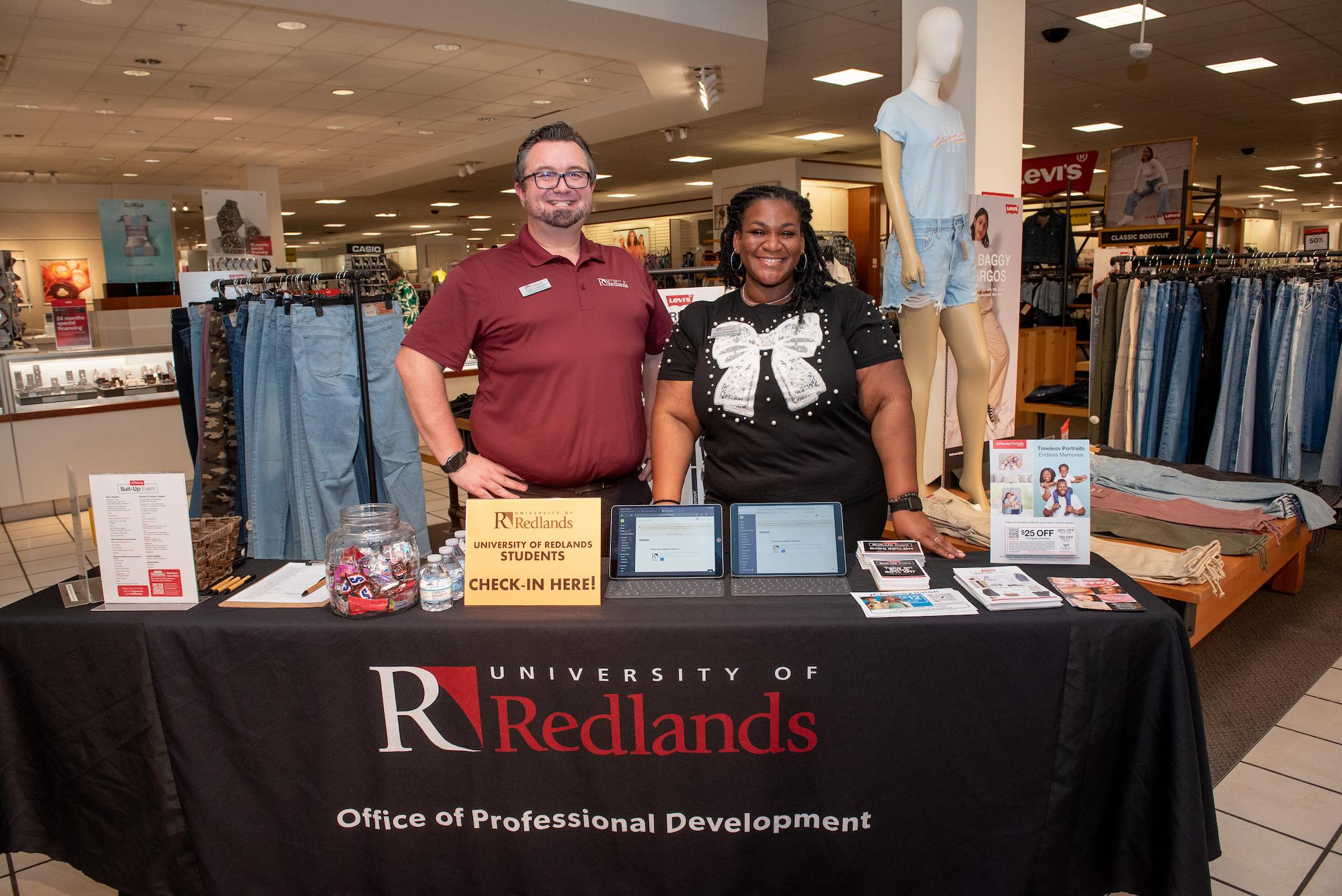 a man and woman standing behind a table