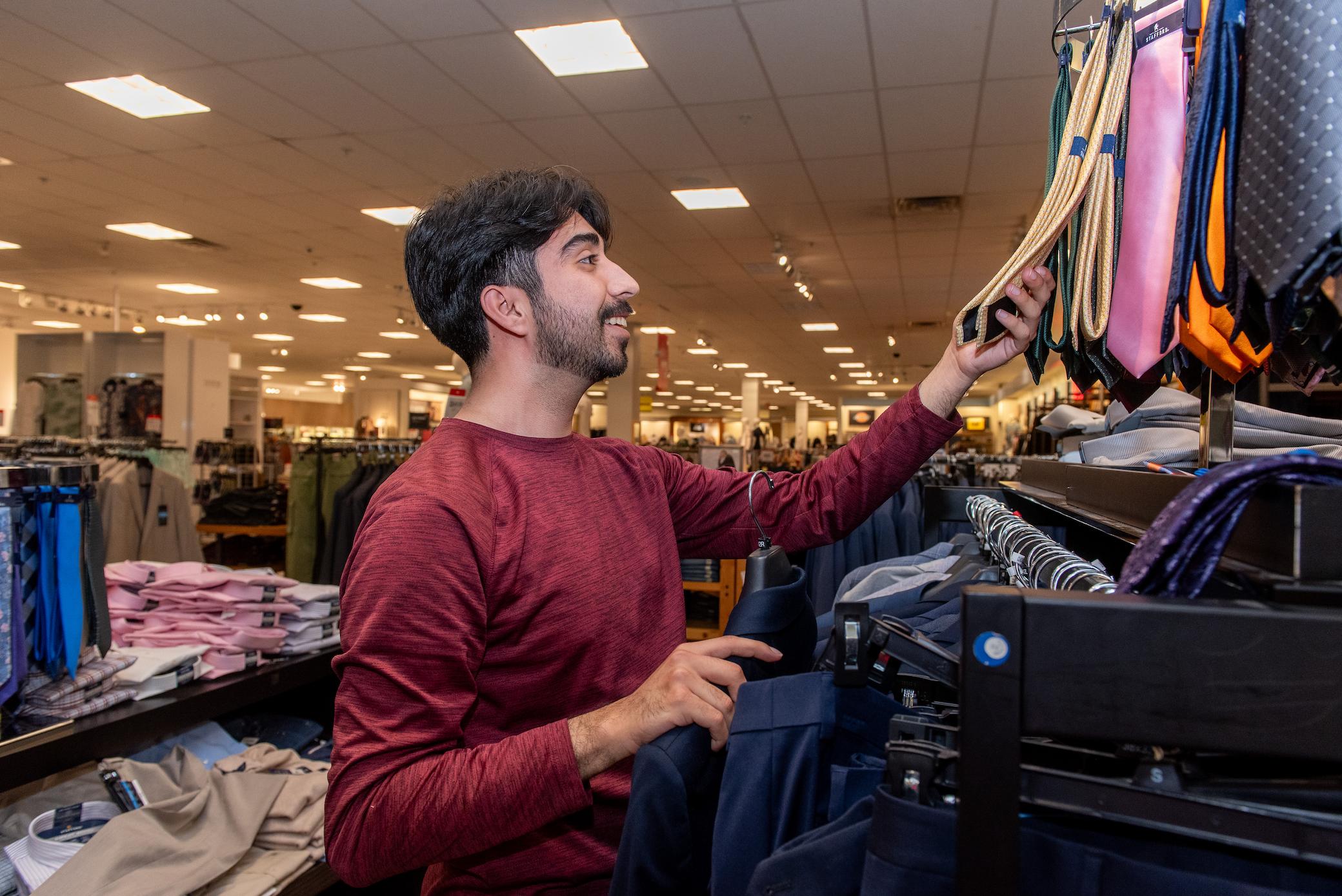 a man looking at a swinger with a variety of clothes on it