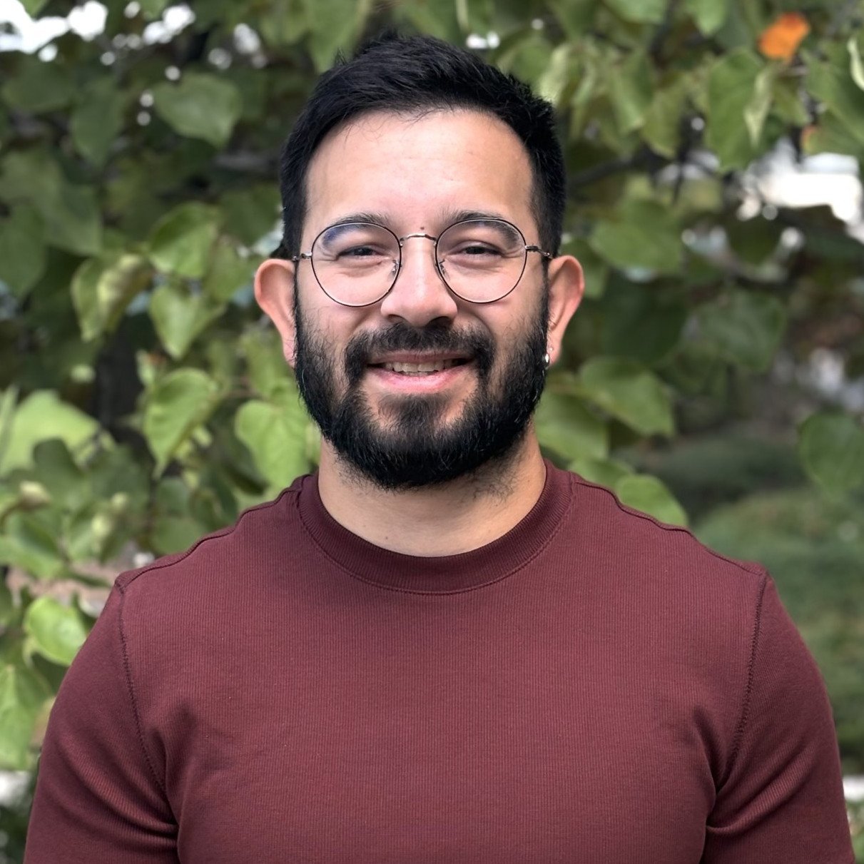 a man with beard and glasses smiling