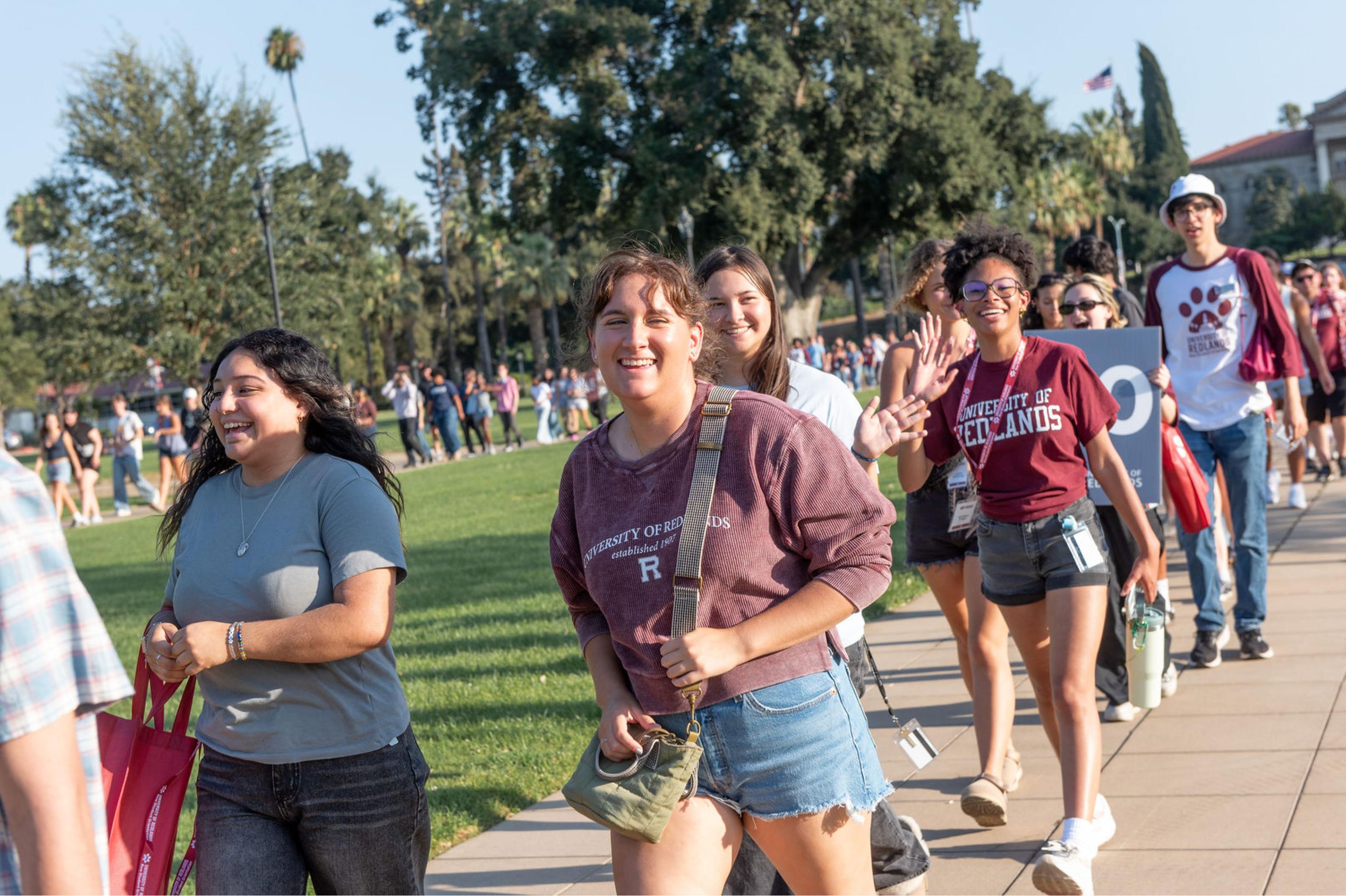 a group of people walking on a sidewalk