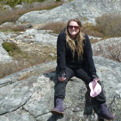 a woman sitting on a rock