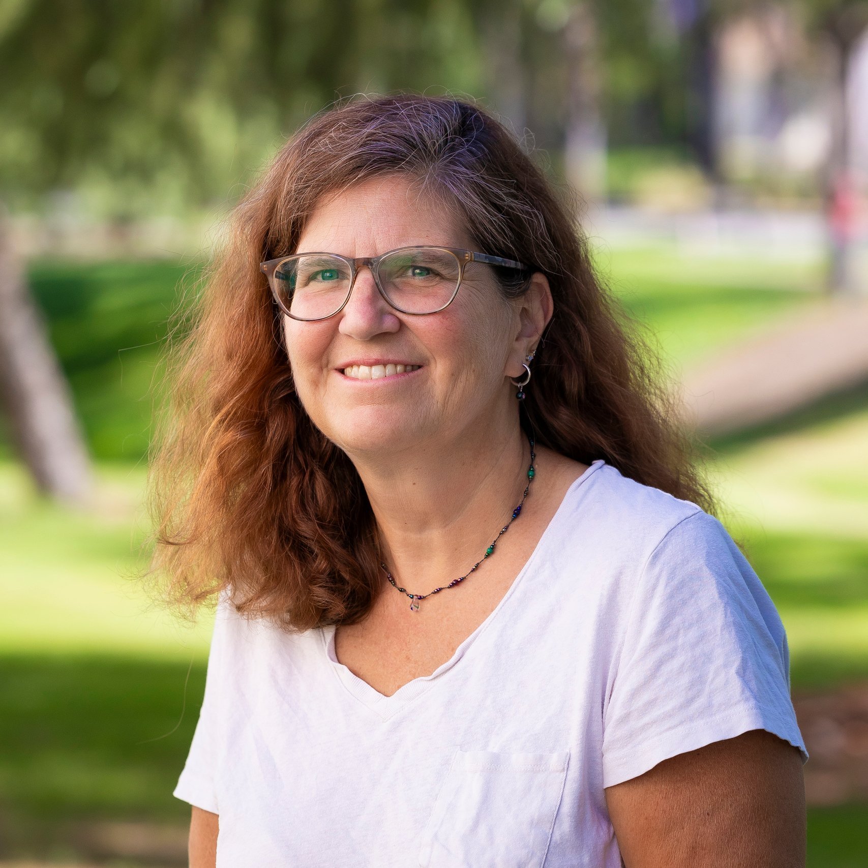 a woman wearing glasses and a white shirt