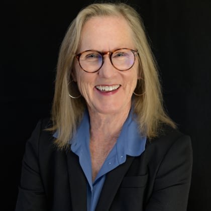 a woman wearing glasses and a suit