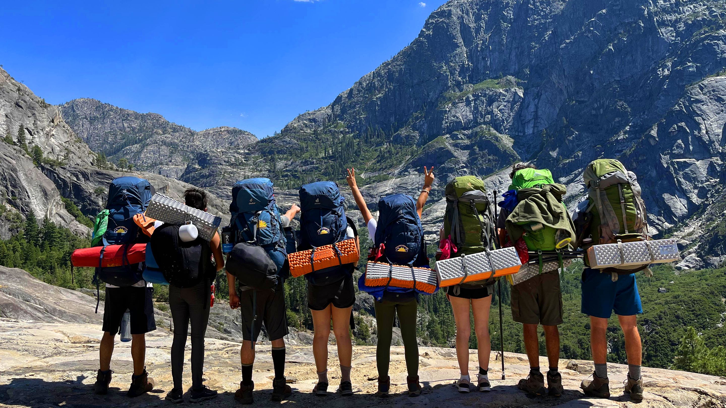 a group of people with backpacks on a mountain