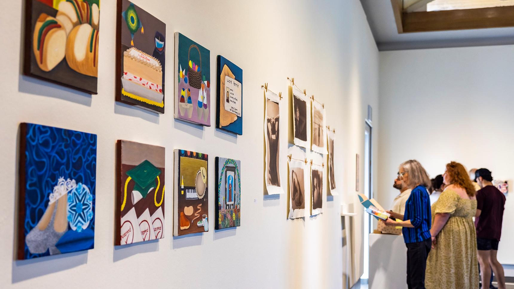 a man looking at pictures on a wall