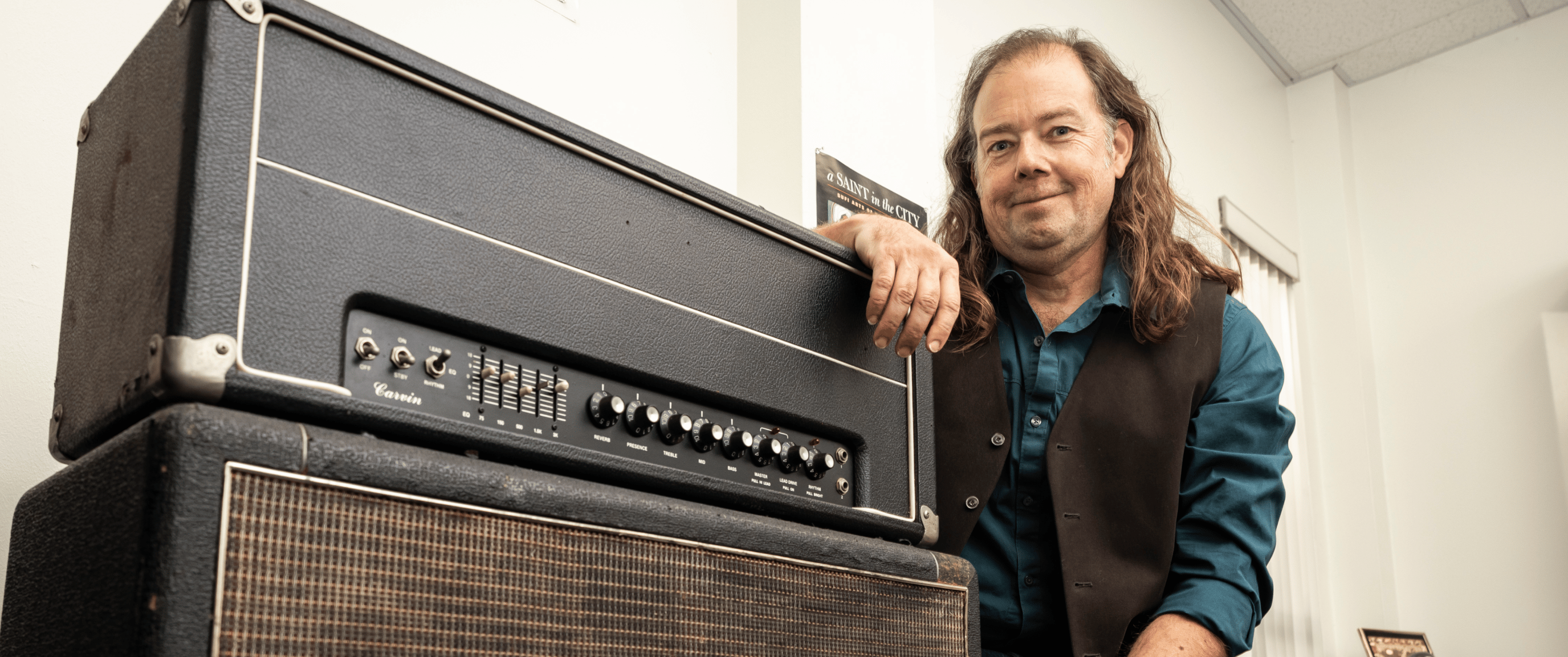 a man leaning on a amplifier