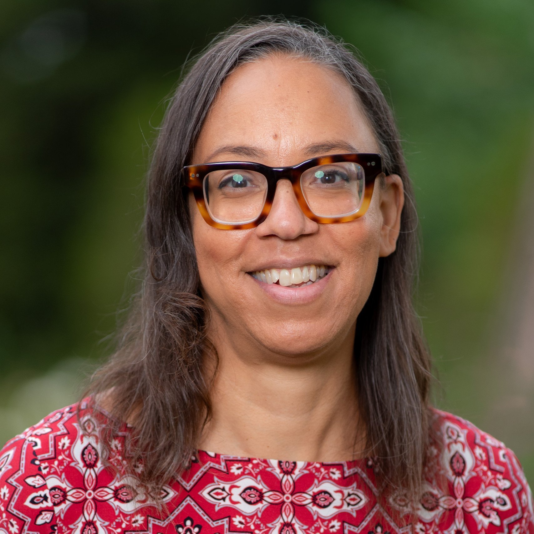 a woman wearing glasses smiling