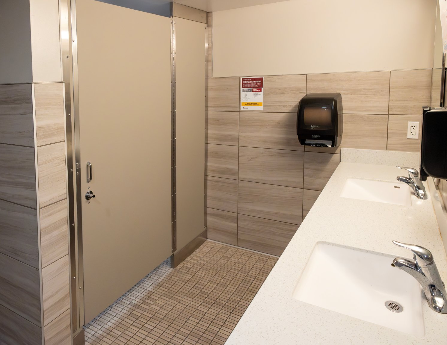 a bathroom with two sinks and a paper towel dispenser