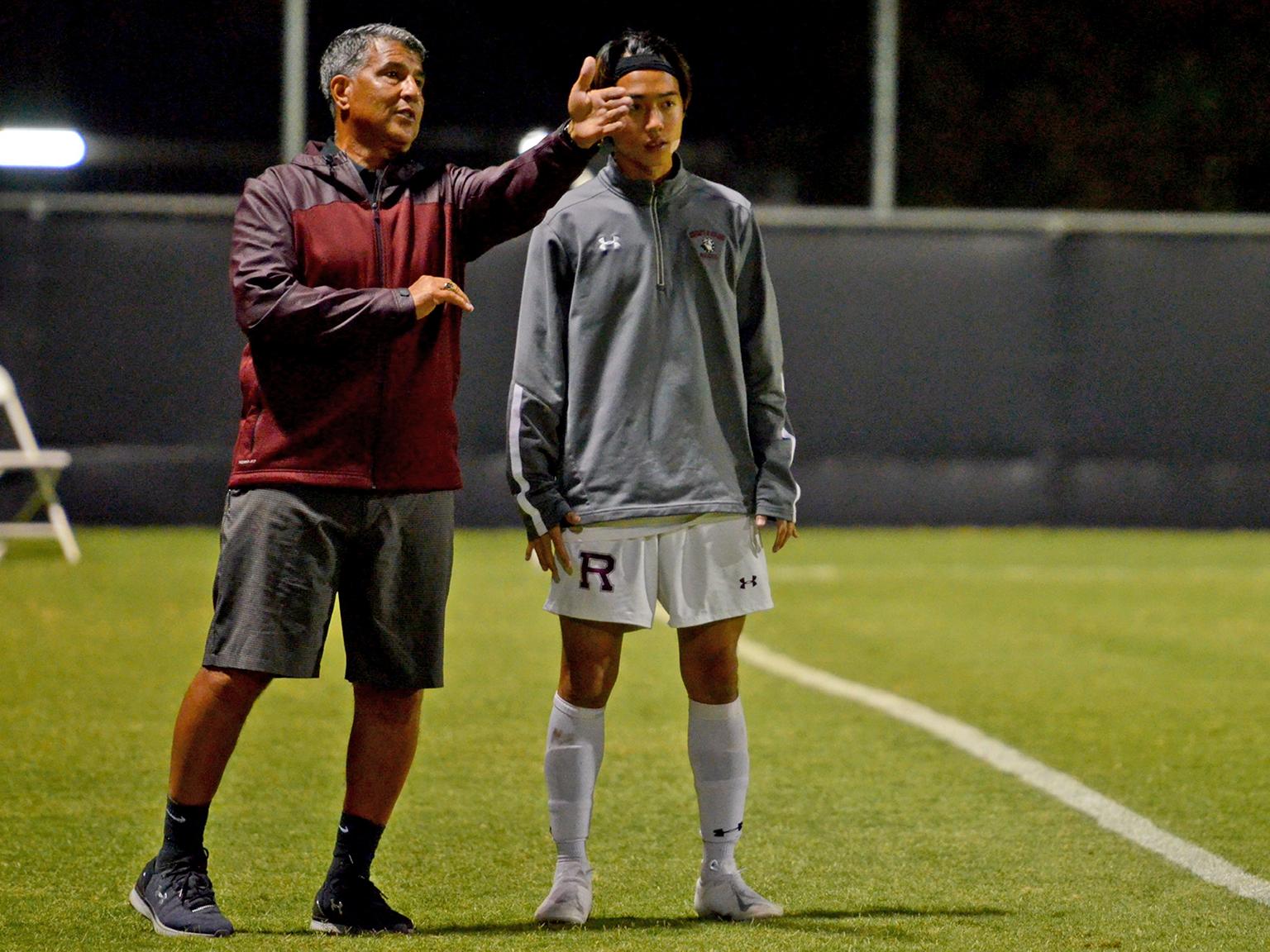 a man giving a high five to a man on a football field