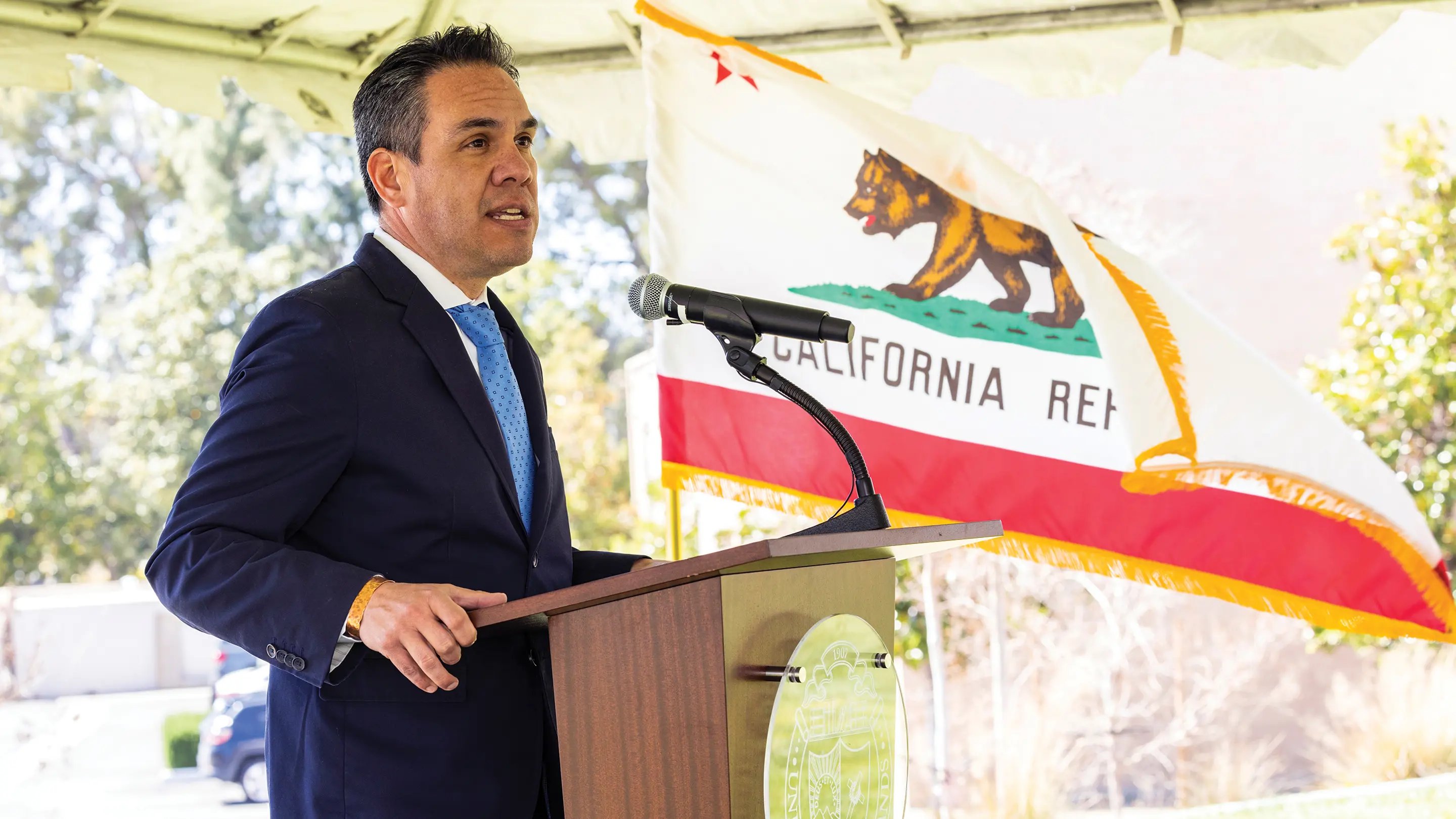 a man standing at a podium with a microphone