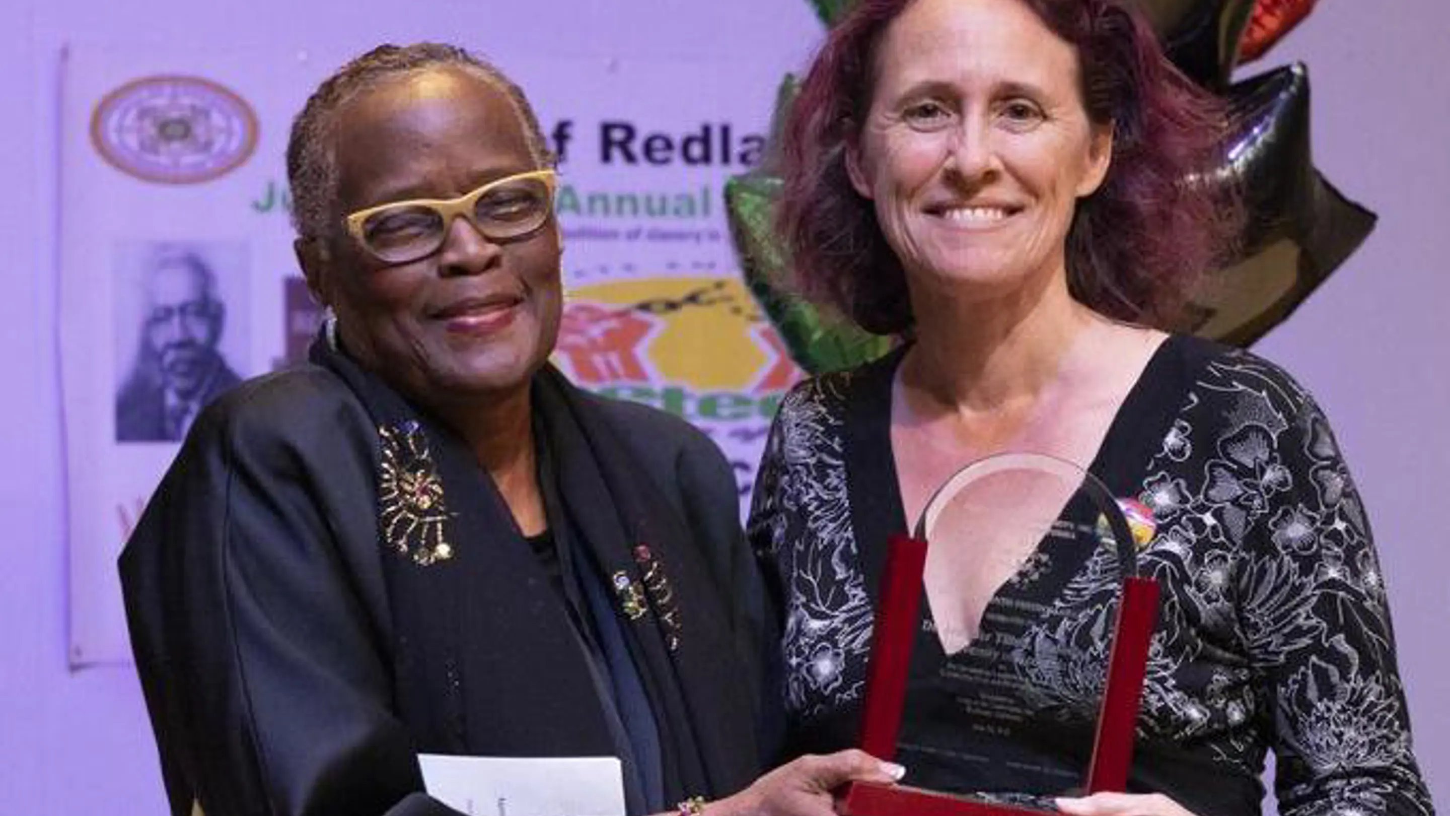 two women holding a trophy