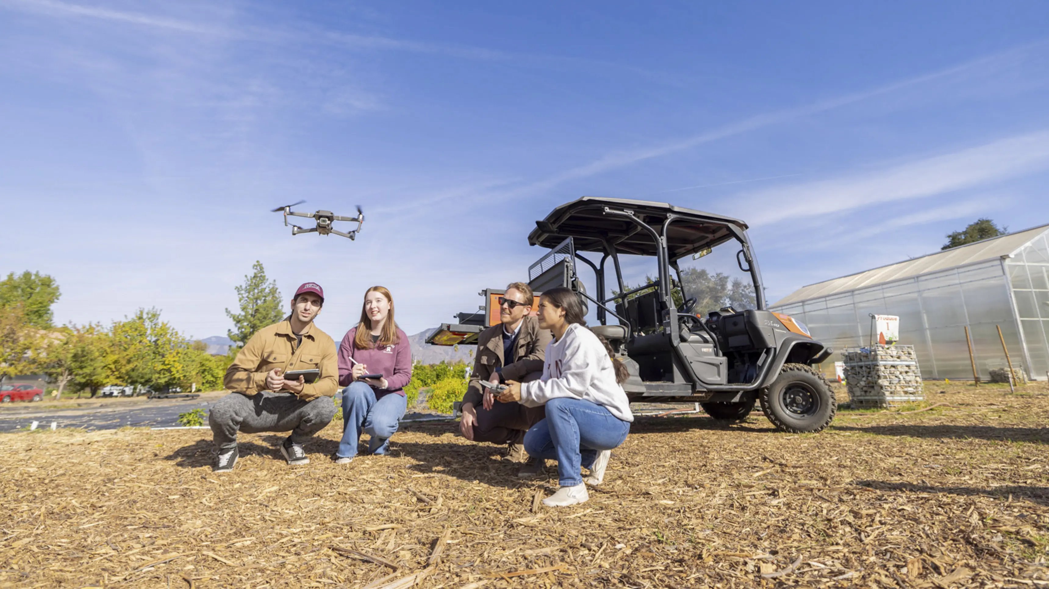 a group of people sitting next to a drone