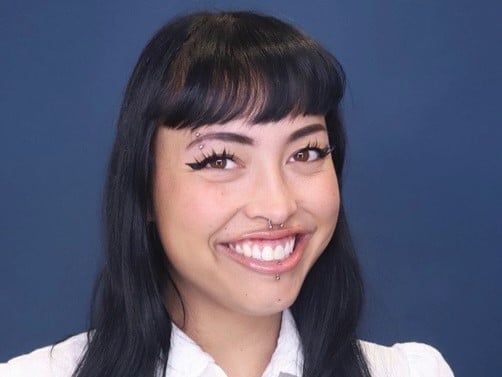a woman with piercings and nose ring smiling
