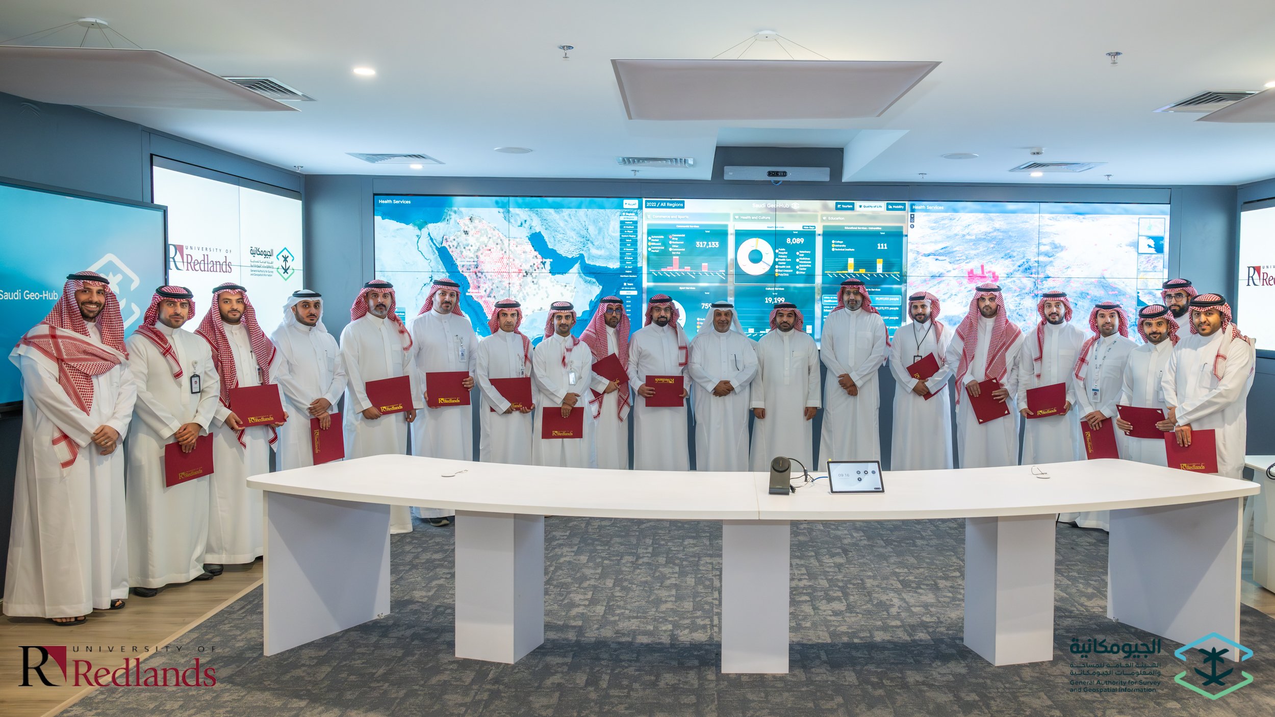a group of men wearing white robes and holding red folders