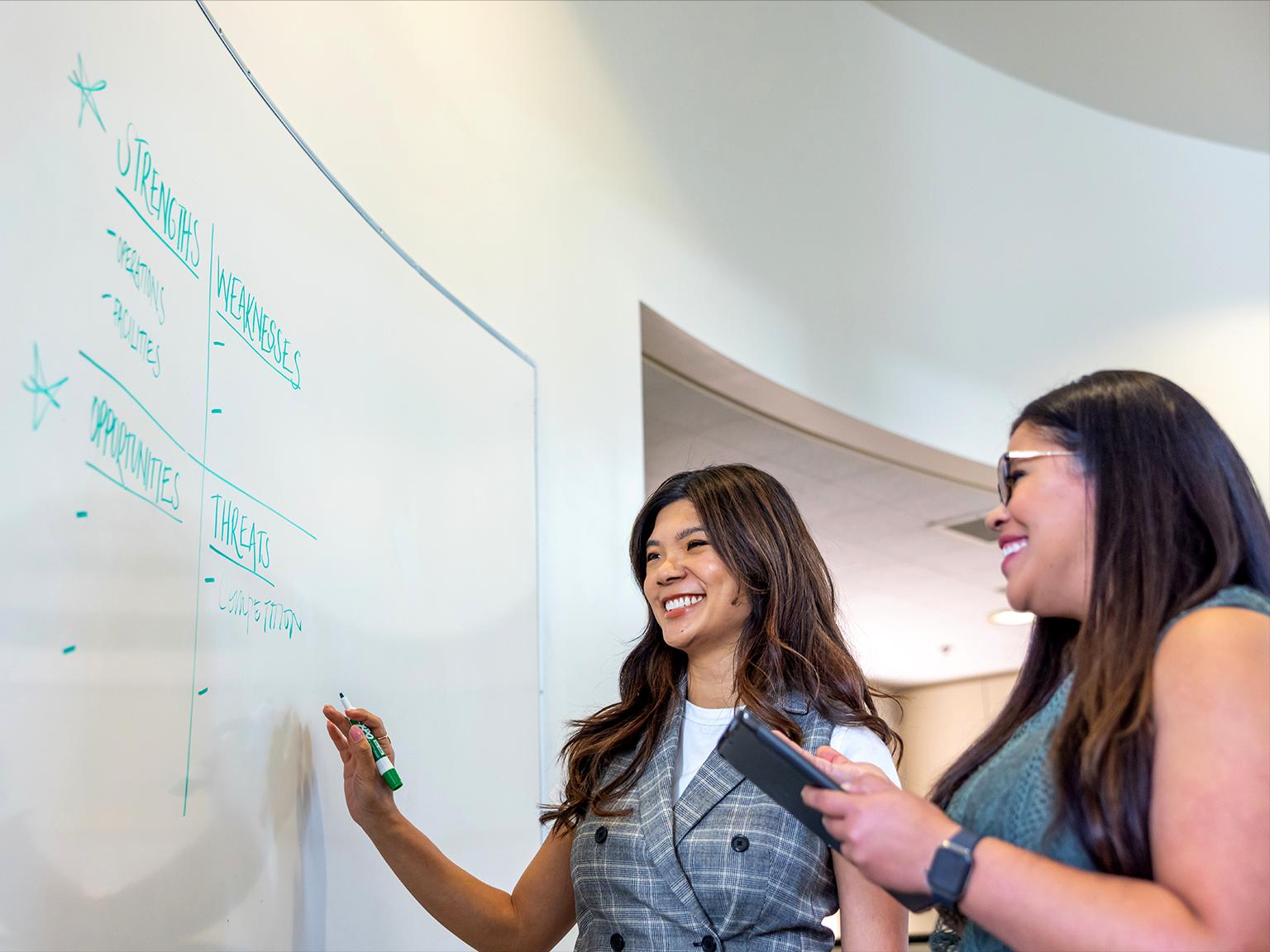 a group of women writing on a whiteboard