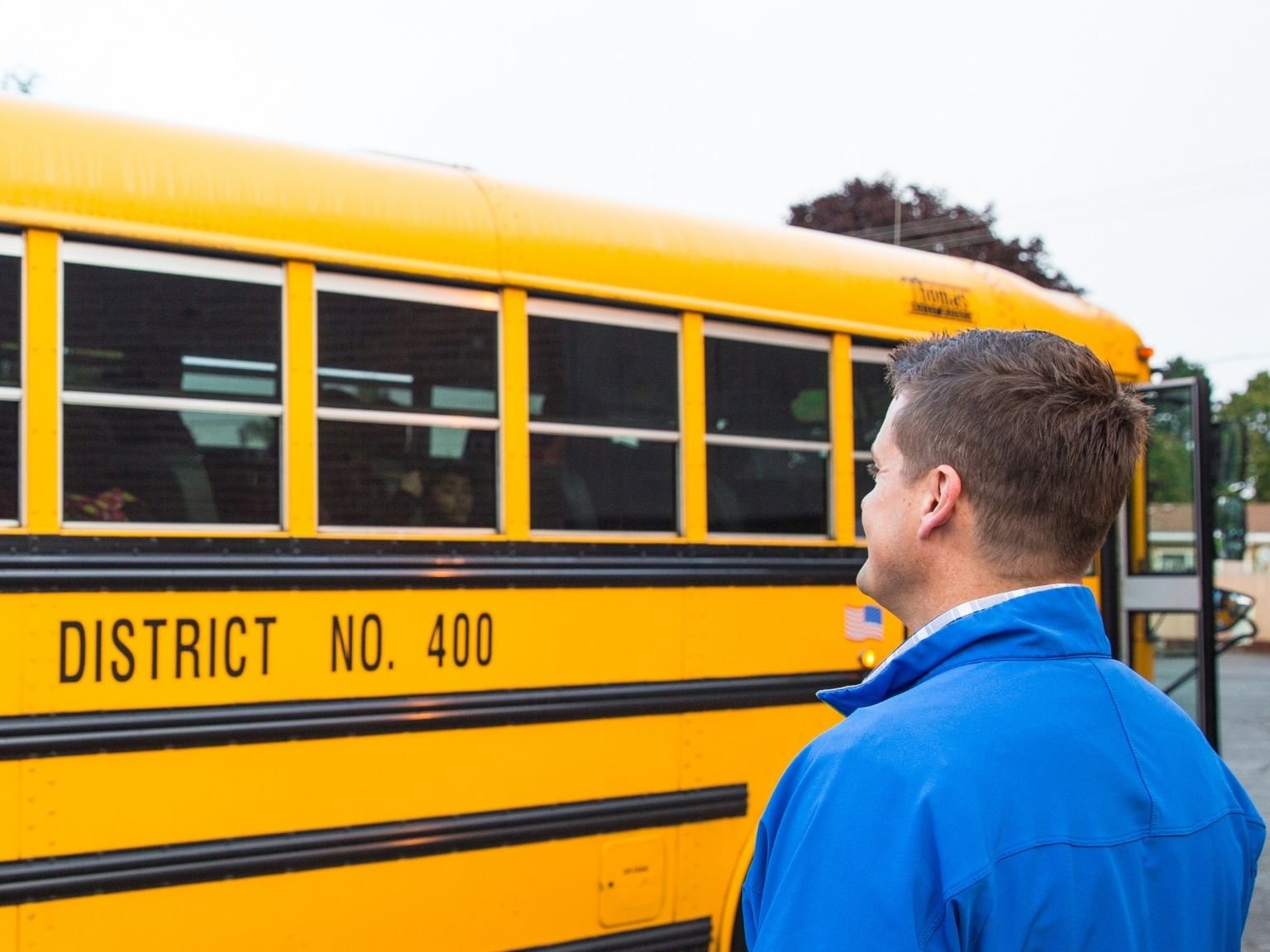 a man standing next to a school bus