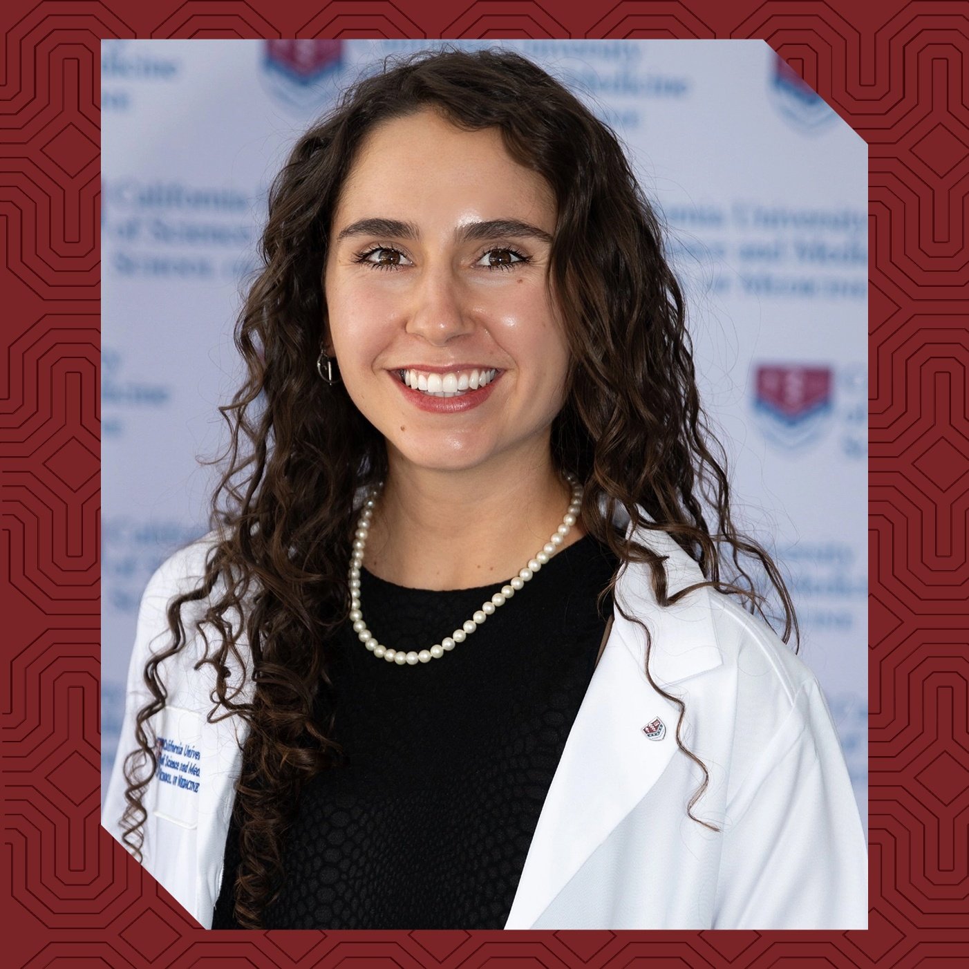 a woman with long curly hair wearing a white lab coat