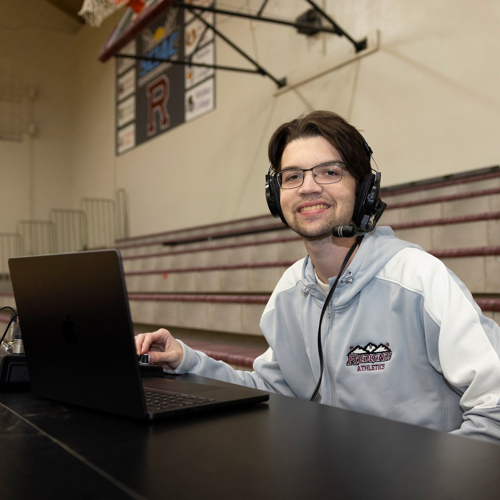 a man wearing headphones and using a laptop