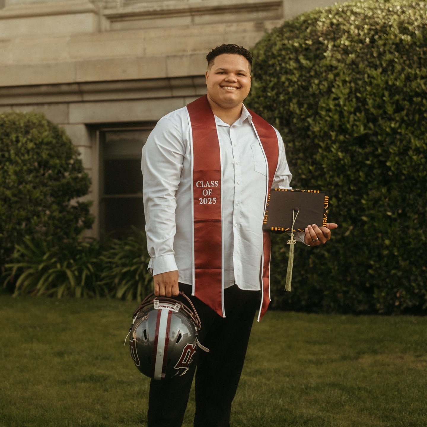 a man wearing a graduation cap and a red and white scarf