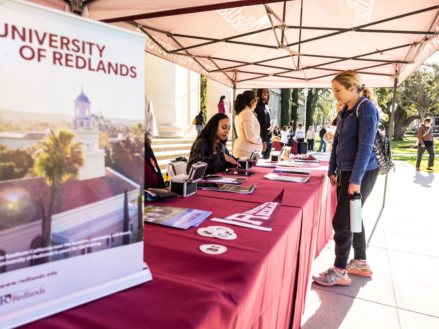 a group of people standing outside under a tent
