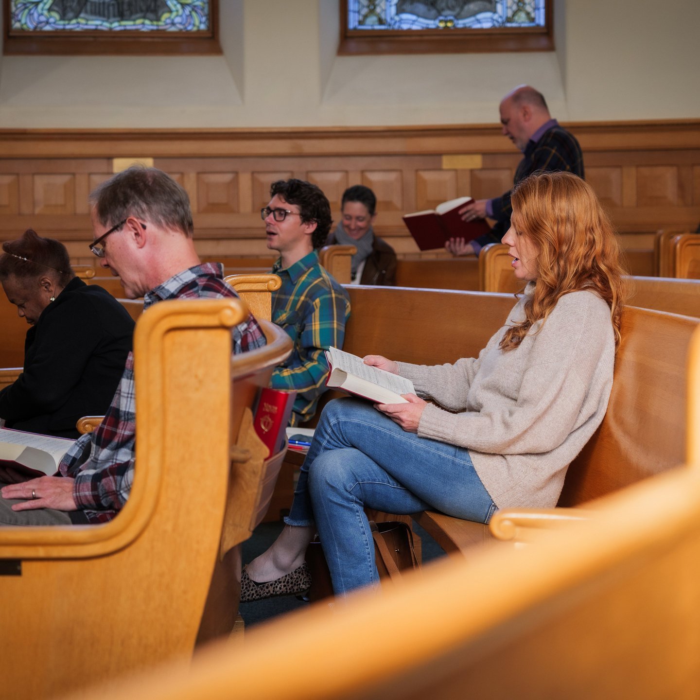 a group of people sitting in pews reading books
